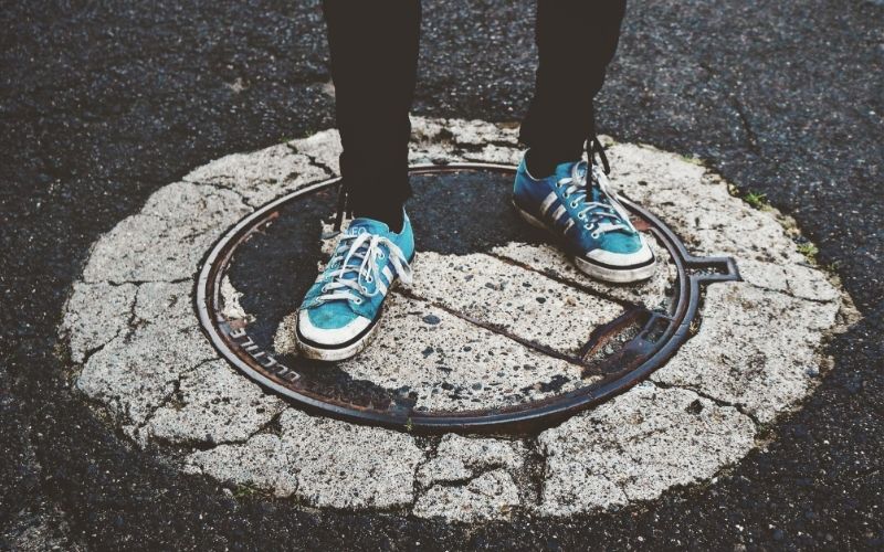 Person Standing on Manhole Cover