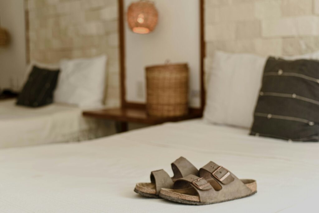 photo of birkenstock shoes on a hotel bed