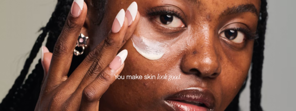 Woman applying under-eye cream with manicured hand